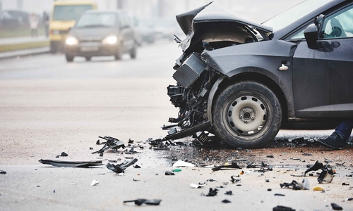 A black car with front-end damage after a collision