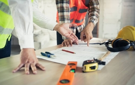 Close up hands of businessman from consultancy service discussing with project contractor and reviewing blueprint for build real estate facilities..jpg