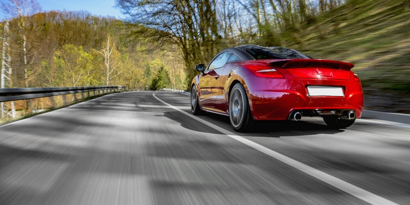 Generic red sports car driving fast on the open road (1).jpg