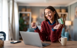 girl in swetaer looking at laptop with creidt card in hand (1).jpg