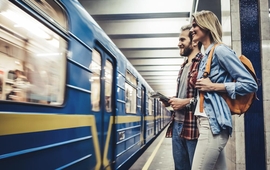 A young couple wait to board a train