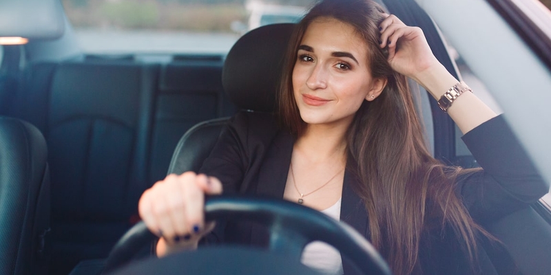 young professional woman driving her car to work