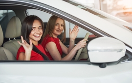 young girl twins sitting on the front passenger seats and smiling.jpg