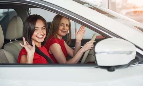 young girl twins sitting on the front passenger seats and smiling.jpg